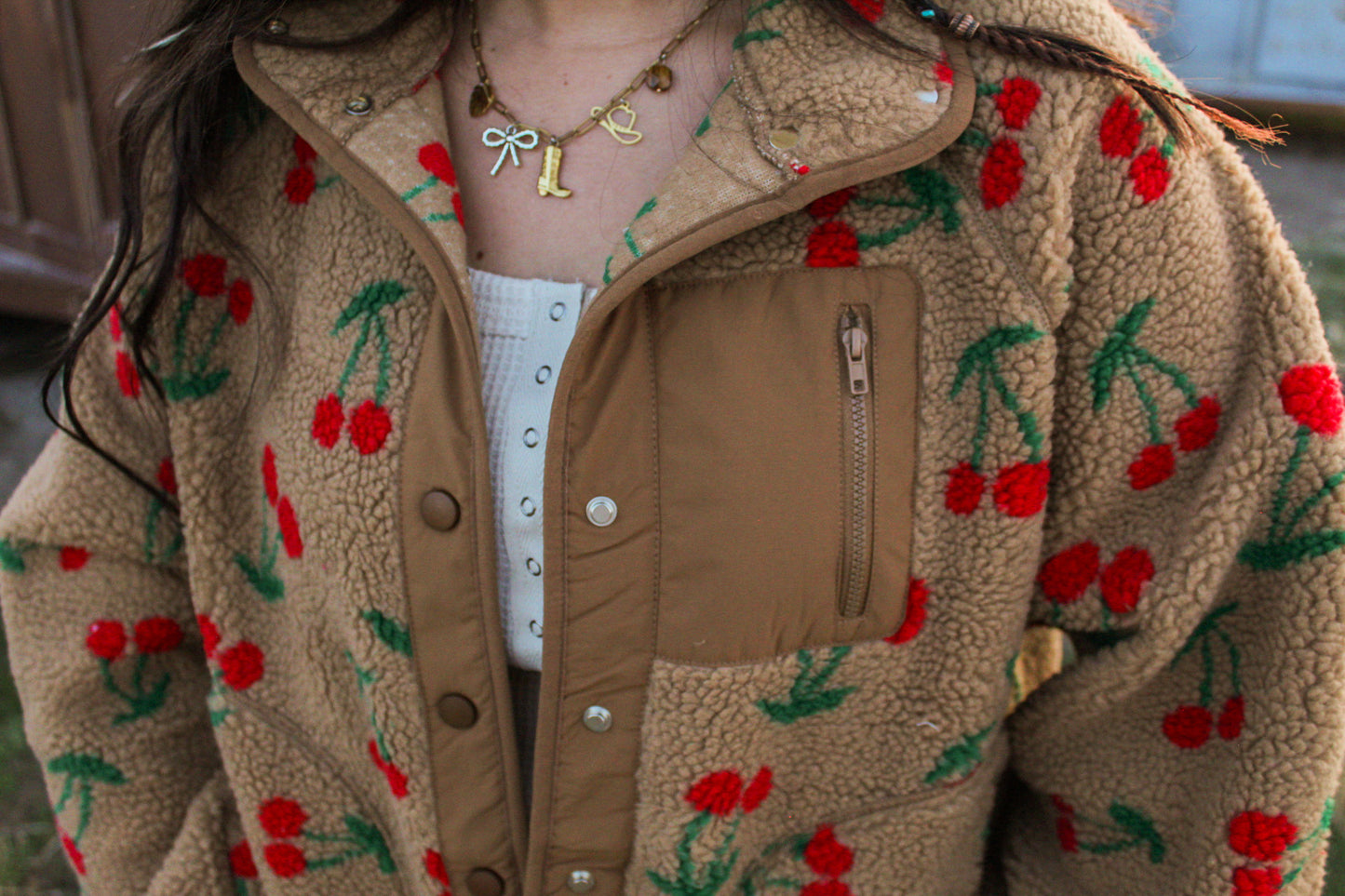 Brown fleece jacket with cherry pattern worn by a person